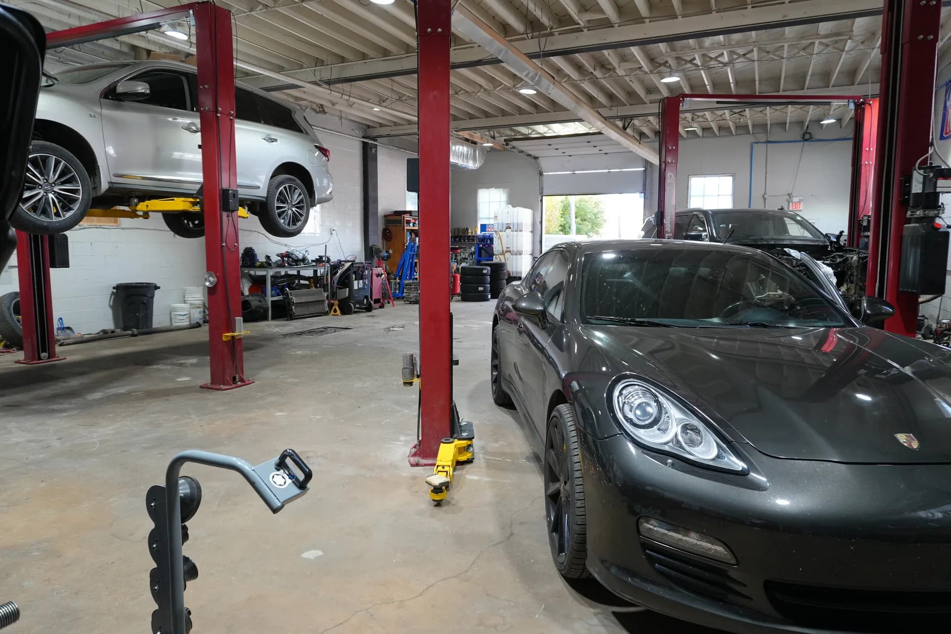 Vehicles and red service lifts inside the Auto Wise workshop.